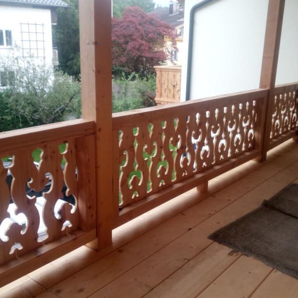 Traditioneller Balkon mit Muster, Laubengang Anbau mit Holztreppe