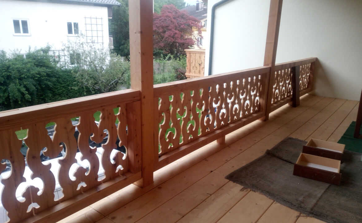 Traditioneller Balkon mit Muster, Laubengang Anbau mit Holztreppe