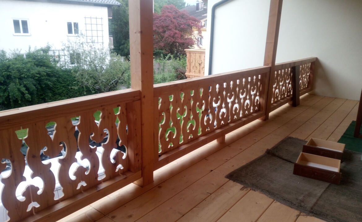 Traditioneller Balkon mit Muster, Laubengang Anbau mit Holztreppe